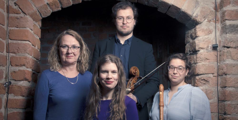 Fyra personer står framför en murad byggnad, medlemmar i Ensemble Barabarock