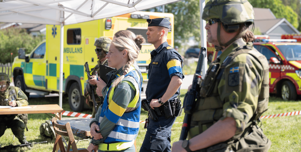 En grupp människor som står i gräset.